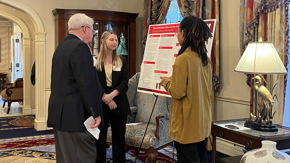 Photo Credit: State Sen. Rick Holdcroft (left) speaks with seniors Lauren Behnk (center) and Meklit Aga (right), who presented their project.