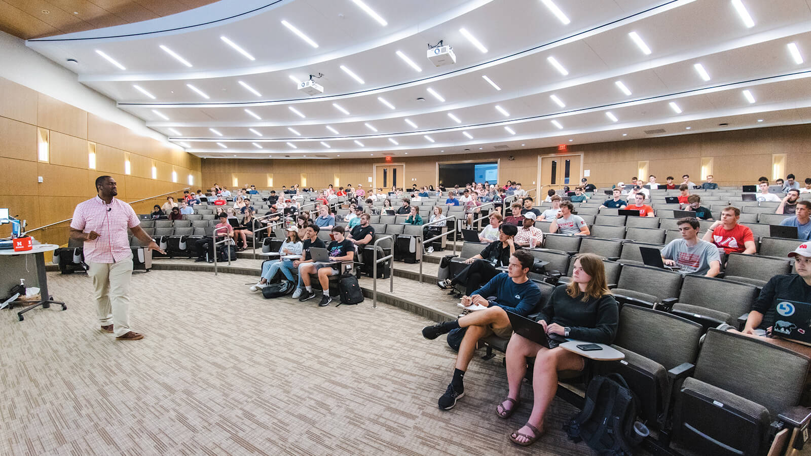 Faculty member talking to students in classroom