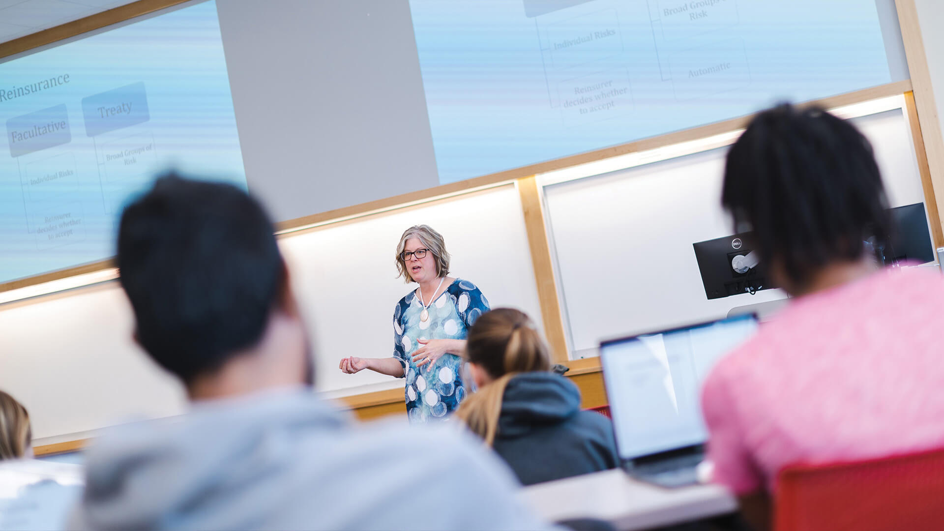 Faculty member talking to students in classroom