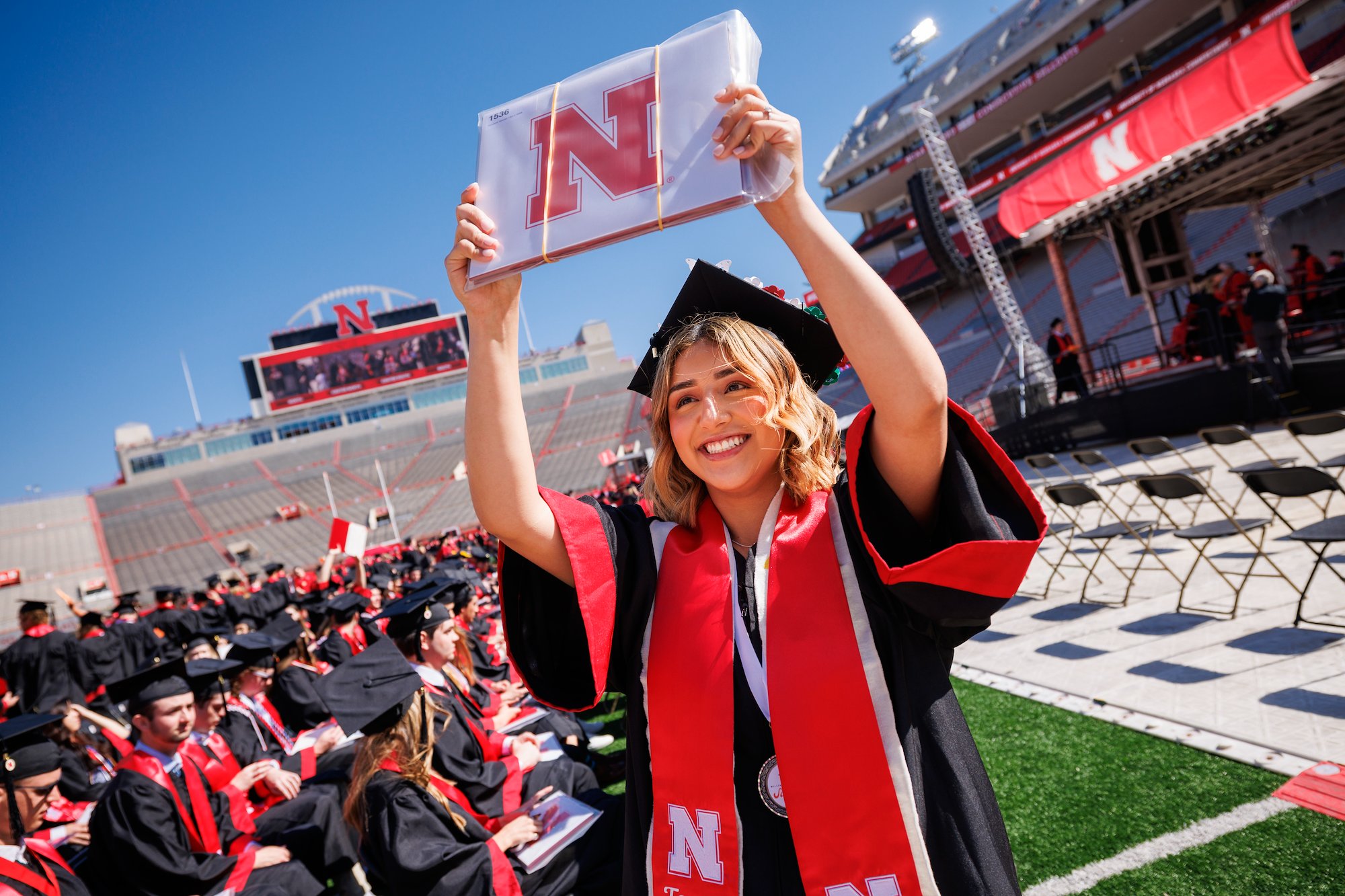 Graduate holding up degree at commencement