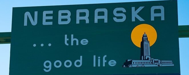 Nebraska road sign featuring the text "the good life" and an illustration of a capitol building.