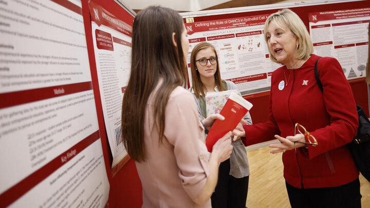 Donde Plowman, executive vice chancellor and chief academic officer, with students during the 2017 Spring Research Fair.