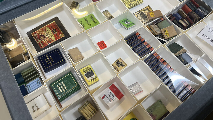 The gallery includes storage cabinets, and as the miniatures are catalogued, they are added to the gallery storage. Here, a drawer of books includes a set of Encyclopedia Britannica, telephone directories and others.