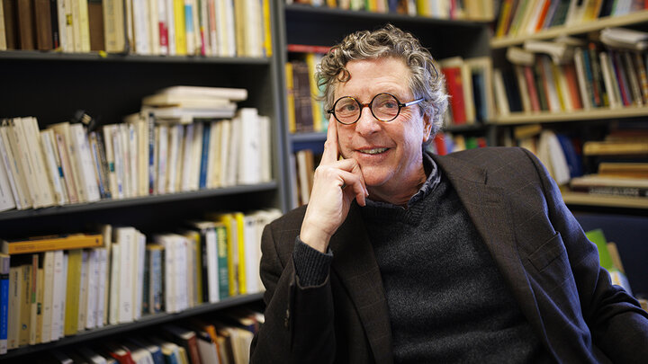 Jordan Stump, professor of French, sits among the books in his office.