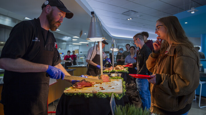 Jake Dietrich (left) serves Grace Clausen at a carving table during the Raikes Beef Co. dinner April 14 at the Cather Dining Center. The event featured hundreds of pounds of beef, all produced some 30 miles east of campus in Ashland.