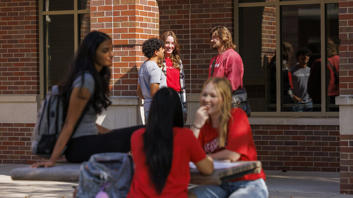 Viraj Karthik, Nick Coldiron, and Kate McKinzie talk outside the Raikes school as they enjoy the fall sunshine.
