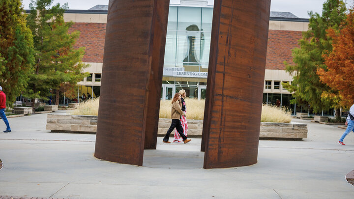 Fans walk through campus, in front of the Adele Hall Learning Commons.
