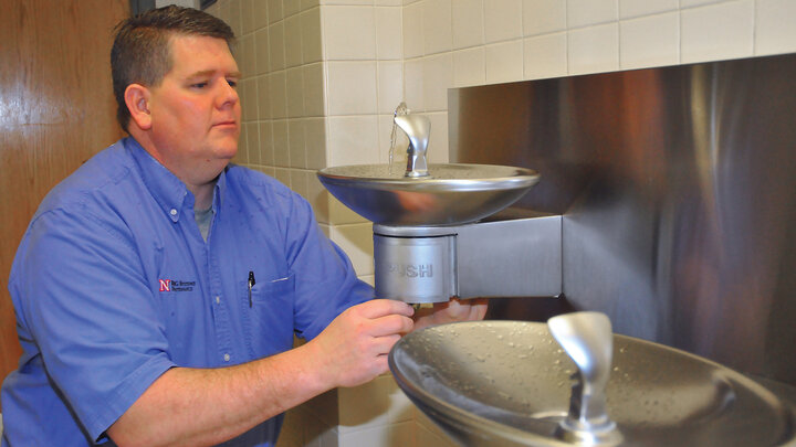 Russ Kraft, a preventative technician with building systems maintenance, adjusts a water fountain in Othmer Hall. UNL is using a student project to guide repairs of fountains across City Campus.