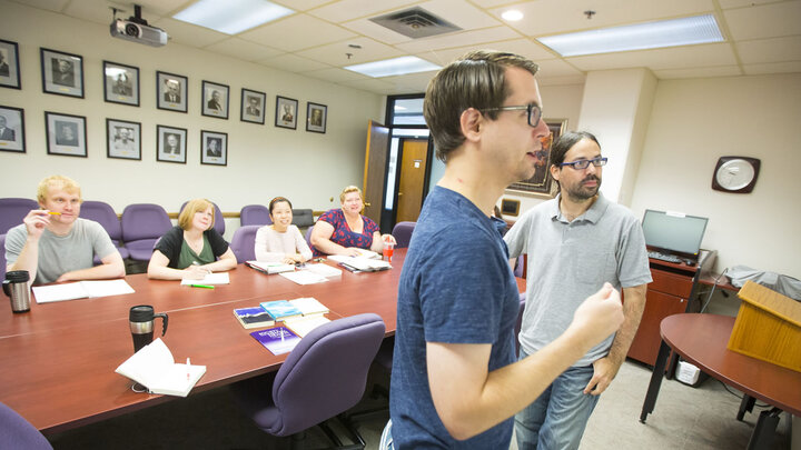 Students and faculty talking in a meeting room