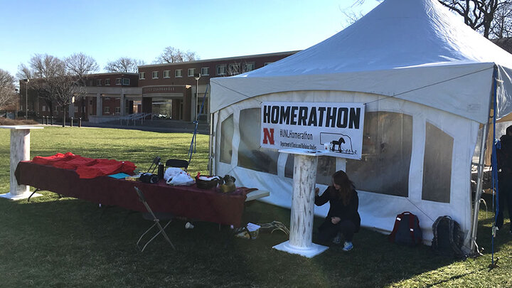 Student next to pillar and Homerathon tent