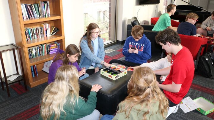 Elijah Shirley with other students playing a board game