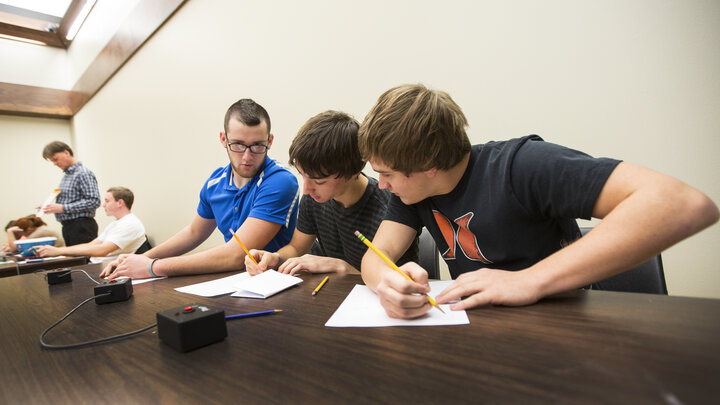 Tucker Merz, Justin Ernst and Preston Deckinger of Falls City High School ponder a math question posed by UNL's Mark Walker as they take on a team from Seward High School on Nov. 21. 