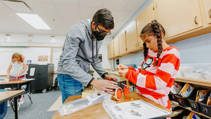 Rohan Tatineni with a student in an afterschool STEM club