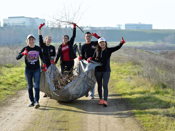Students carrying an item on a road
