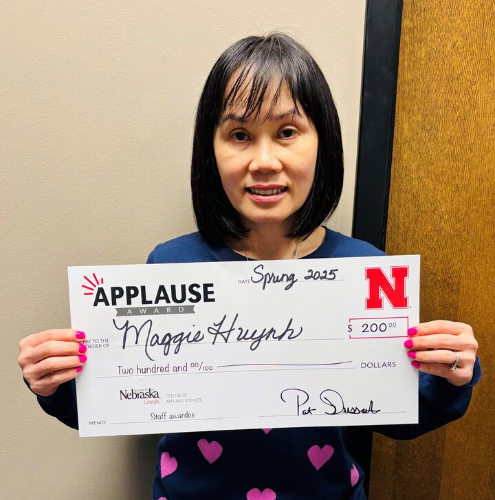 Maggie Huynh receiving applause award check