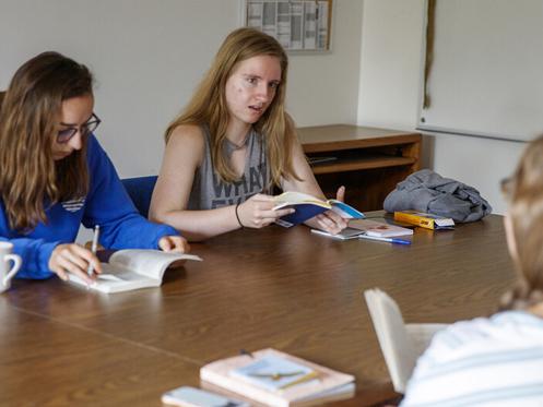 Sarah Hawkinson (left) and Kaylen Michaelis (right) discuss the first few chapters of “O Pioneers!” with their instructor, Emily Rau